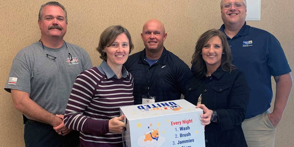 Kosciusko Leadership Academy group photo of five adults holding a United Way Good Night box.