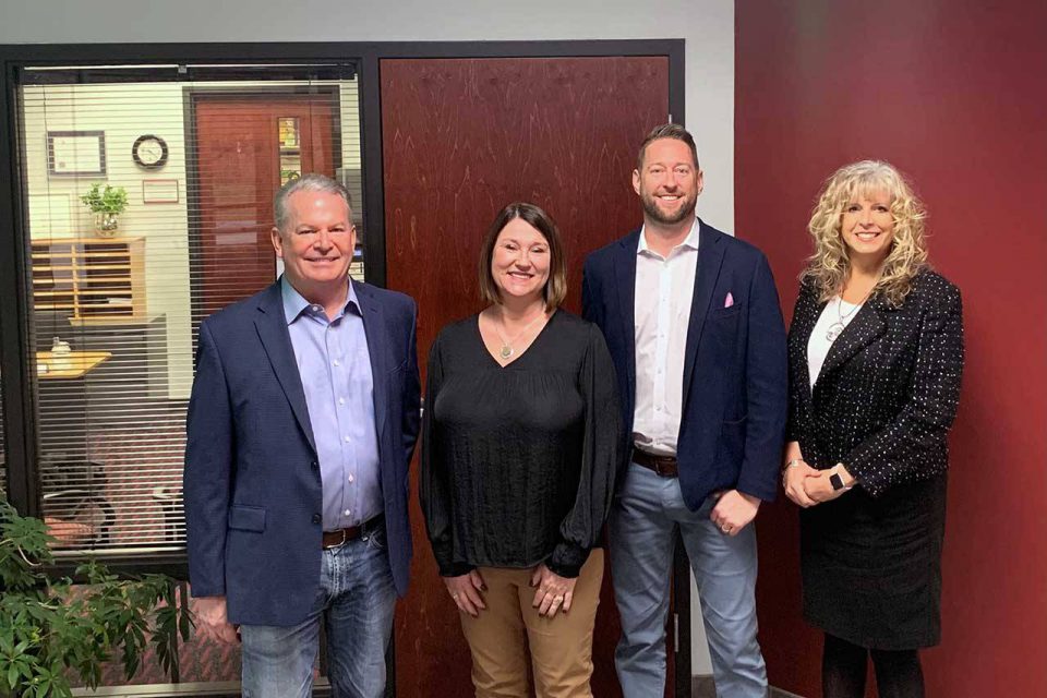 Kosciusko Leadership Academy group photo of four adults in front of an office.