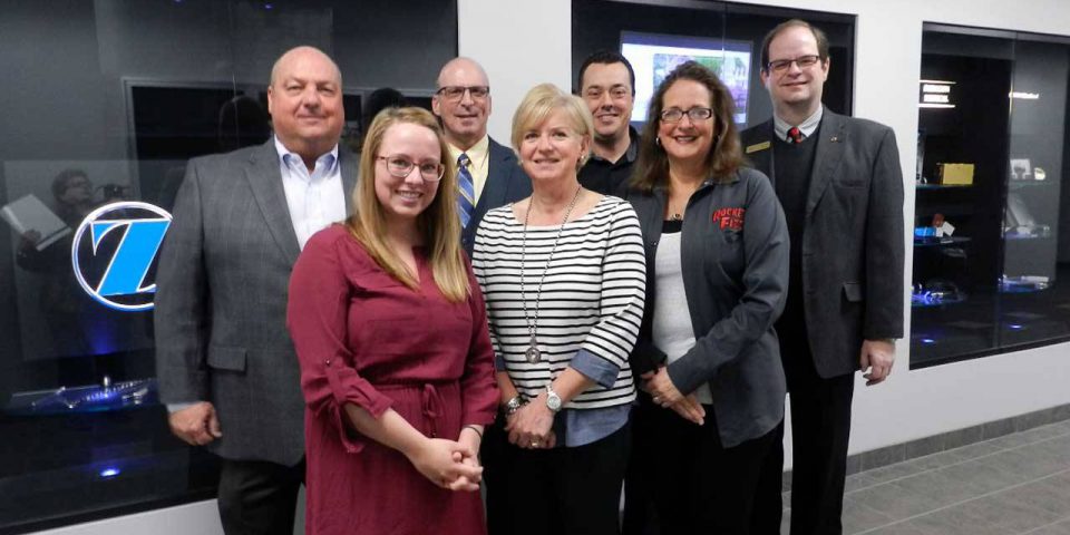 KLA leadership group photographed in front of a Zimmer logo.